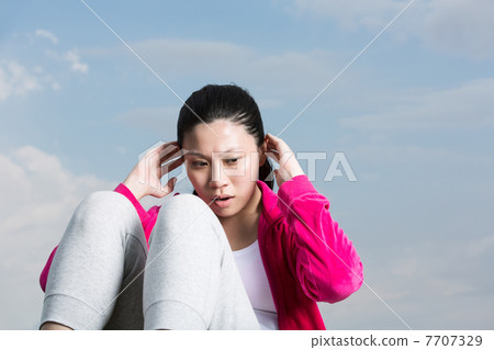 Chinese woman doing situps in park. Chinese woman doing situps in park. 7707329