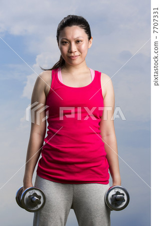Chinese woman exercising with dumbbells. Chinese woman exercising with dumbbells. 7707331