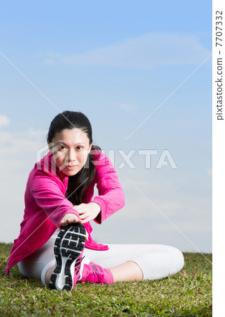 Young Chinese woman stretching before her run. Young Chinese woman stretching before her run. 7707332