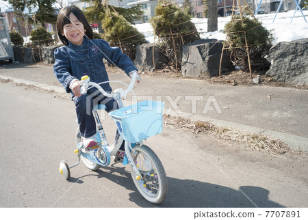 A girl riding a bicycle A girl riding a bicycle 7707891