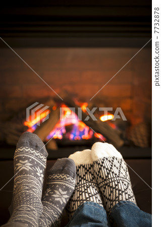 Feet warming by fireplace Feet warming by fireplace 7732878