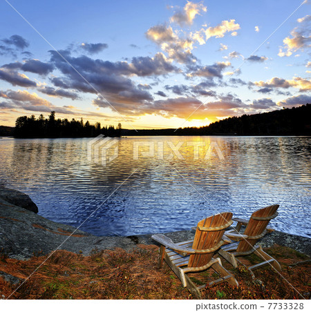 Wooden chairs at sunset on beach 7733328