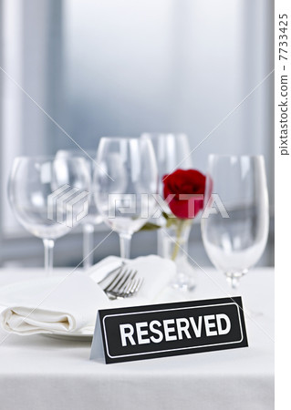 Romantic dinner setting with reserved sign Romantic dinner setting with reserved sign 7733425