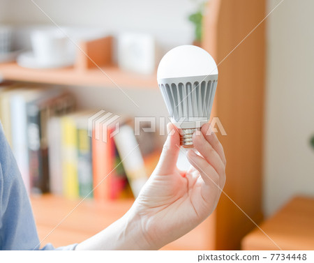 A woman with an LED bulb 7734448