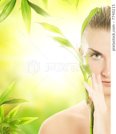 Beautiful young woman with a bamboo plant Beautiful young woman with a bamboo plant 7740215