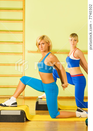 Beautiful women exercising in fitness club Beautiful women exercising in fitness club 7740302