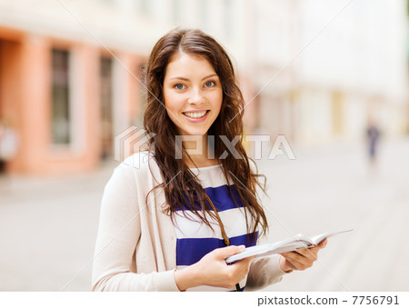 girl looking into tourist book in the city 7756791