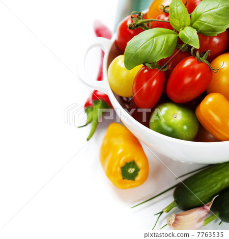 Assorted tomatoes and vegetables in colander 7763535