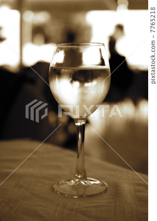 Glass of white wine on a table (toned in sepia) Glass of white wine on a table (toned in sepia) 7765218