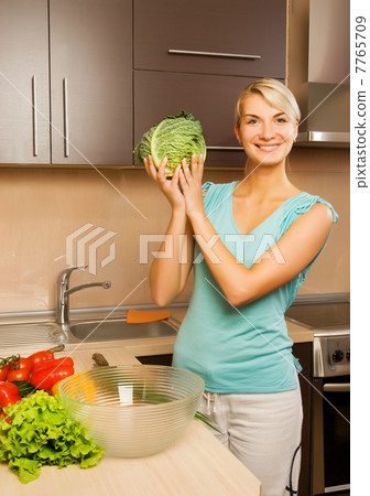 Beautiful young woman making vegetarian vegetable salad 7765709