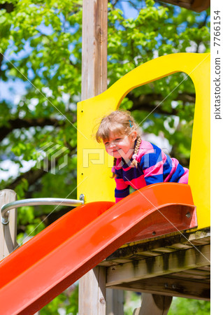 Little Kid on a jungle gym slide 7766154