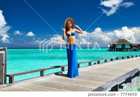 Woman on a beach jetty at Maldives 7774659
