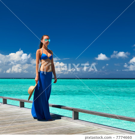 Woman on a beach jetty at Maldives Woman on a beach jetty at Maldives 7774660