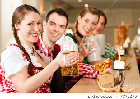 Young people in traditional Bavarian Tracht in restaurant or pub Young people in traditional Bavarian Tracht in restaurant or pub 7776270