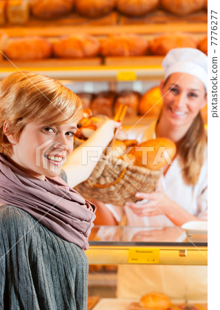 Salesperson with female customer in bakery 7776277