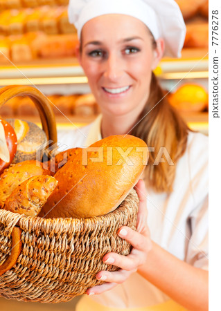 Female baker selling bread by basket in bakery 7776278
