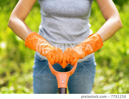 Woman in orange gloves working in the garden 7781250
