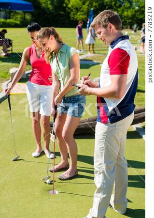 People playing miniature golf outdoors 7783219