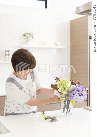 A woman who arranges flowers in the kitchen A woman who arranges flowers in the kitchen 7792142