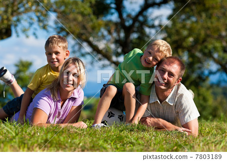 Family with children and football on a meadow 7803189