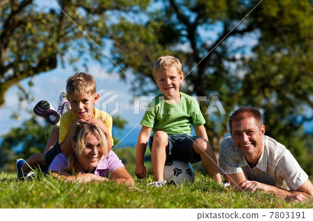 Family with children and football on a meadow 7803191