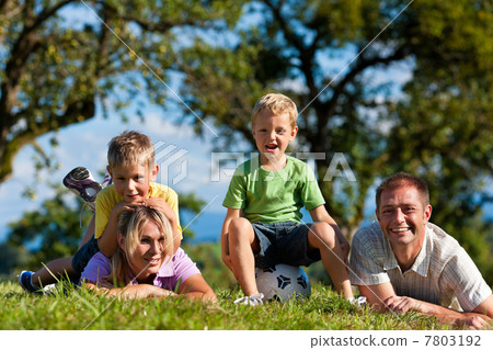 Family with children and football on a meadow Family with children and football on a meadow 7803192