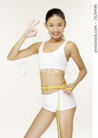 Young woman measuring waistline 7826496