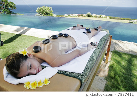 Womon lying on massage table outdoors 7827411