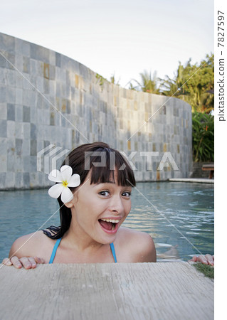 Young woman standing in swimming pool 7827597