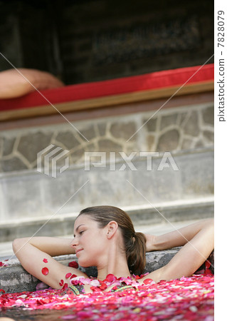 Woman having flower bath 7828079