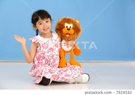 Little girl holding a plush lion 7828582