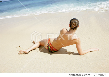 Young woman enjoying sunbath on the beach 7829028