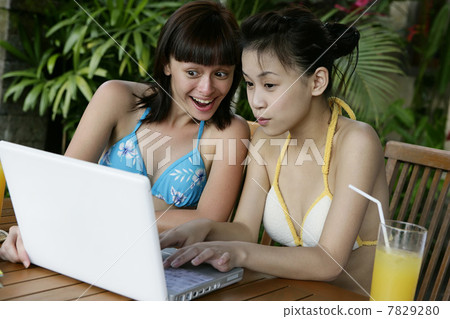 Two young women checking computer 7829280