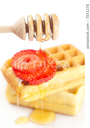 Belgian waffles and strawberries on a plate, stick for honey and Belgian waffles and strawberries on a plate, stick for honey and 7831278