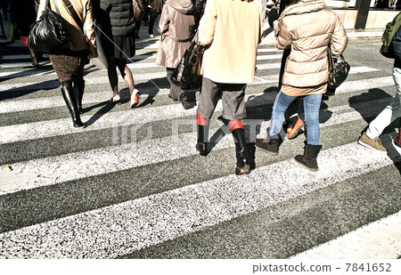 A pedestrian going through a pedestrian crossing 7841652