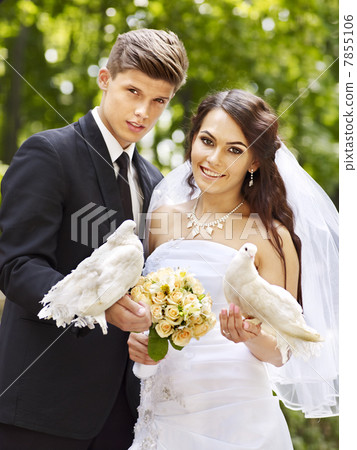 Bride and groom holding dove outdoor. 7855106