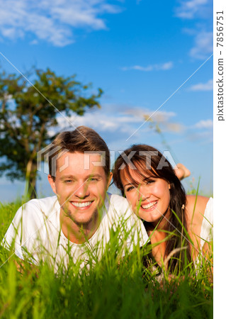 Happy couple lying on a meadow Happy couple lying on a meadow 7856751