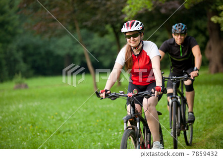 Man and woman riding bicycles Man and woman riding bicycles 7859432
