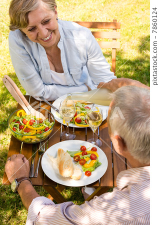 Retired couple eating and drinking outdoors 7860124
