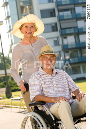 Wealthy senior man in wheelchair with wife Wealthy senior man in wheelchair with wife 7860125