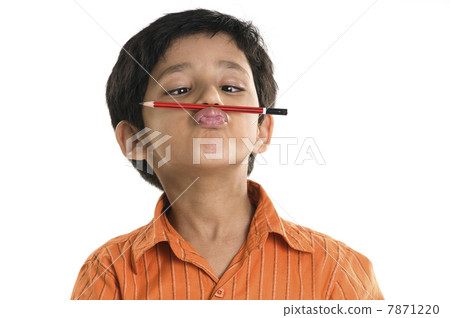 A boy with a pencil between his nose and lips  7871220