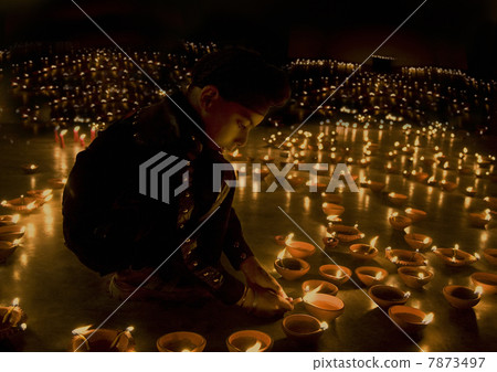 A boy lighting diyas  7873497