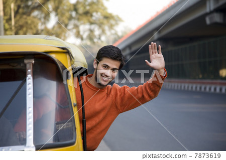 Man waving from an auto rickshaw Man waving from an auto rickshaw 7873619