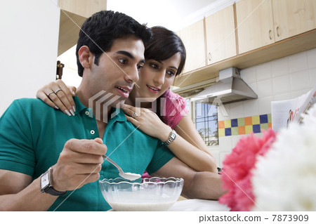 Couple looking at the morning newspaper Couple looking at the morning newspaper 7873909