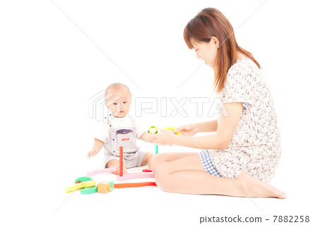 Baby playing with a toy with your mother in the room 7882258