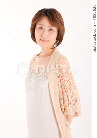 一個四十多歲的女人，雙手背後帶著溫柔的微笑姿勢 7883620