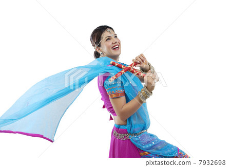 Gujarati woman dancing with dandiya sticks 7932698