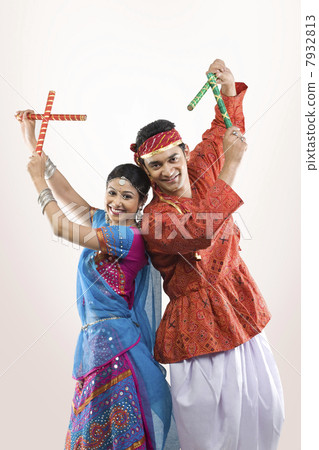 Gujarati couple performing dandiya Gujarati couple performing dandiya 7932813