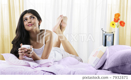Young girl in bed with a cup of coffee 7932871