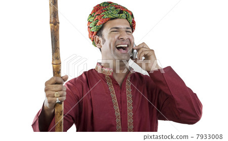 Gujarati man talking on a mobile phone Gujarati man talking on a mobile phone 7933008